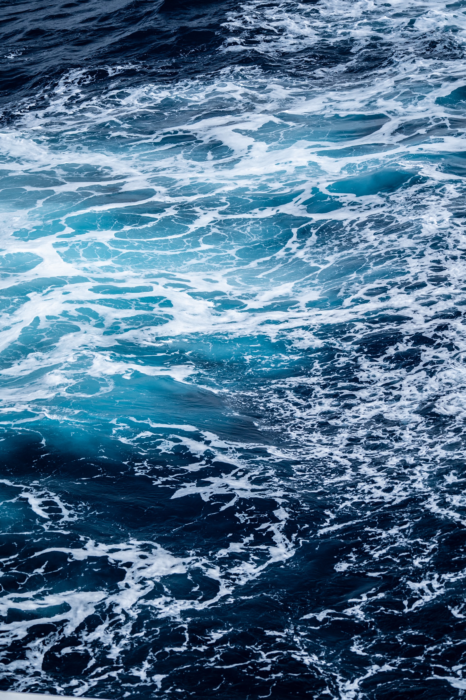Eau de la mer profonde bleu foncée avec de la mousse blanche